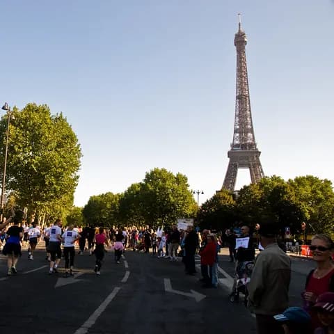 Morning joggers on a bridge with the Eiffel Tower rising behind them